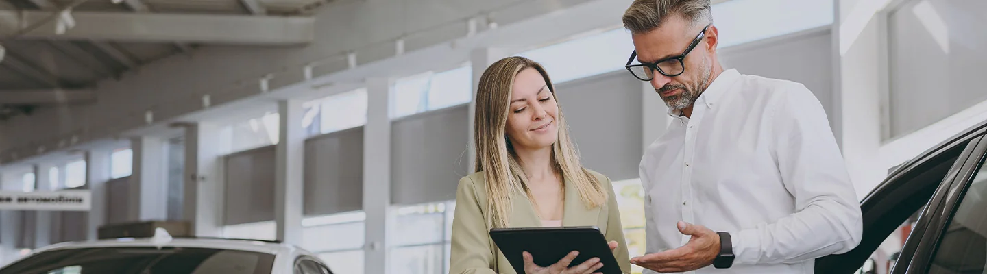 2 people looking at an ipad during a car consultation