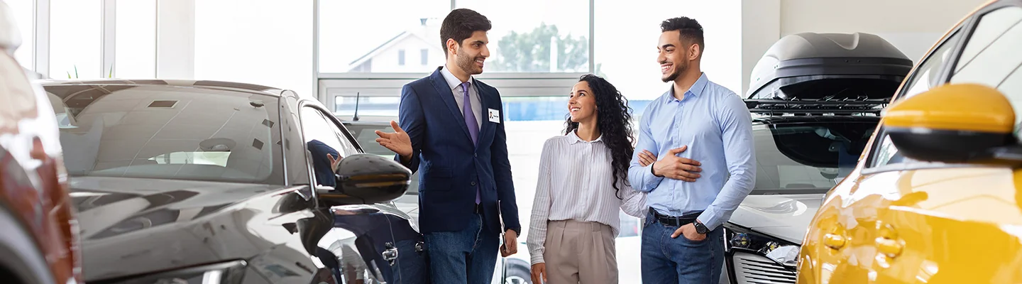 couple looking at a vehicle with the salesman