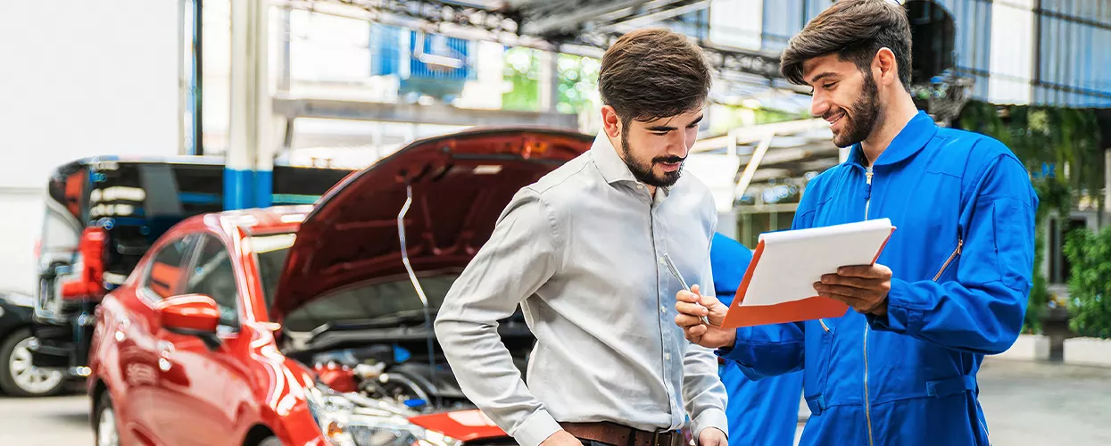 Service mechanic talking to a customer about their vehicle
