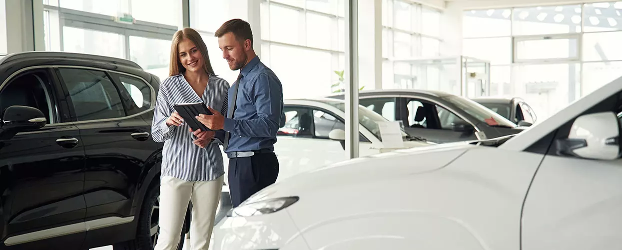 Customer talking to a car salesman at a car dealership