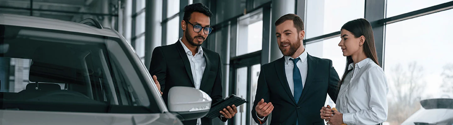 Couple discussing car purchase with salesperson