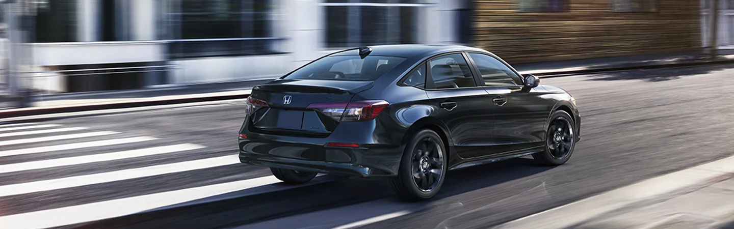 Back view of a black 2026 Honda Civic driving in the city