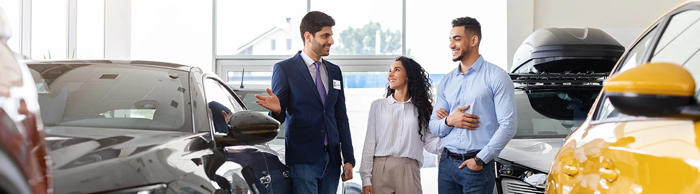 a couple speaking with salesperson in showroom at Volkswagen of Gainesville