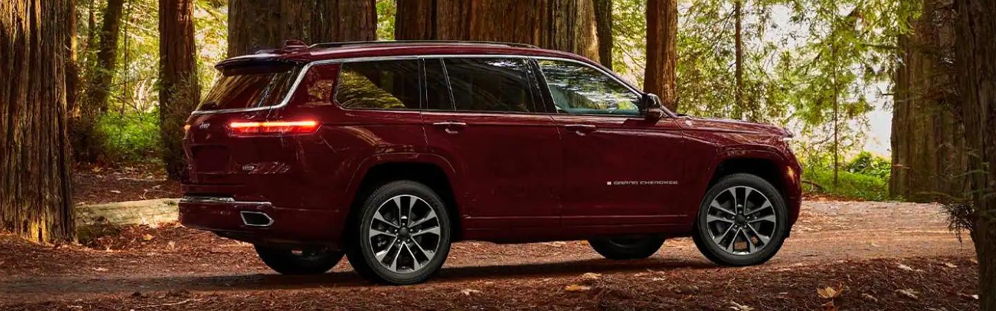 red 2022 Jeep Grand Cherokee L parked in redwoods