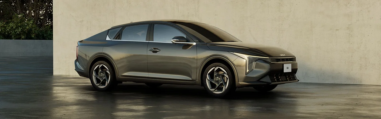 Side view of a parked  2025 Kia K4 next to a wall