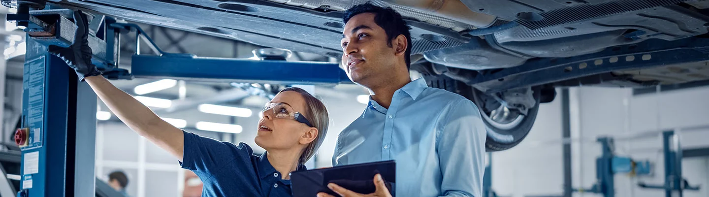 Service technicians looking underneath a vehicle