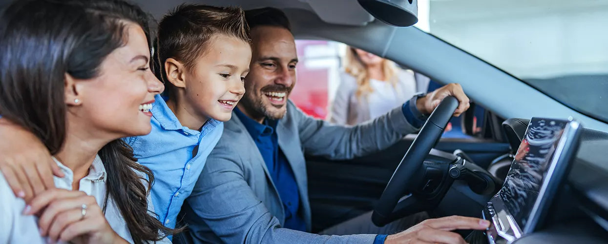 family of three in car smiling on a new Toyota purchase
