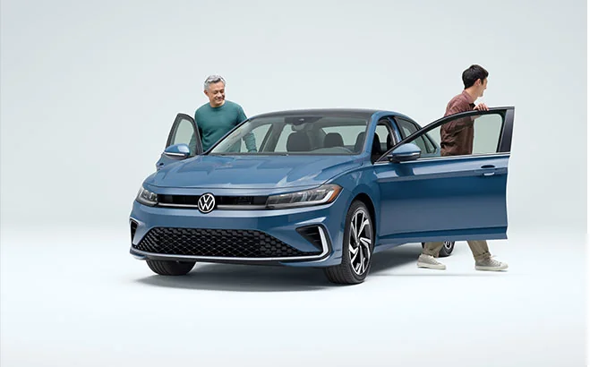 blue Volkswagen front view with two passengers exiting car