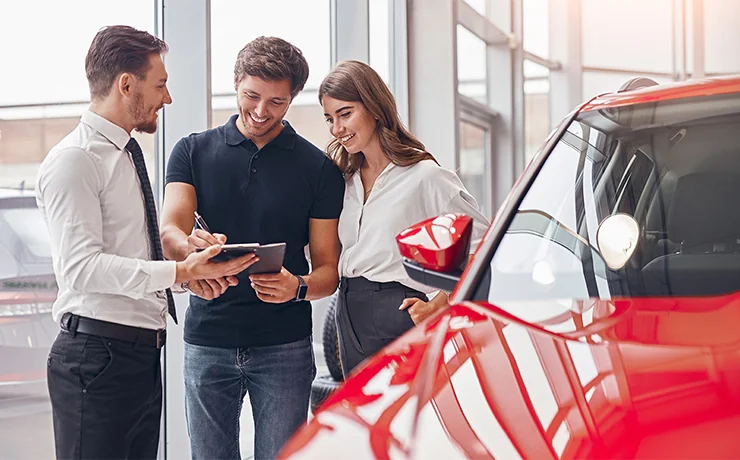 Sales person helping customers shop for a new car