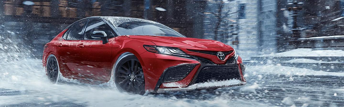 Driving Toyota Camry on the snow-filled road