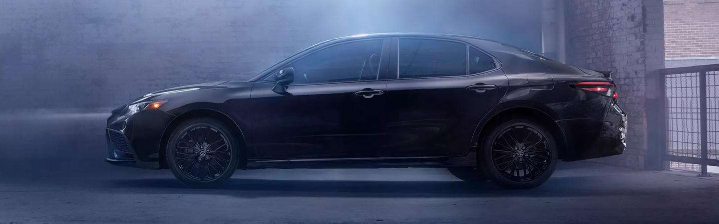 Side profile of a parked black Toyota Camry