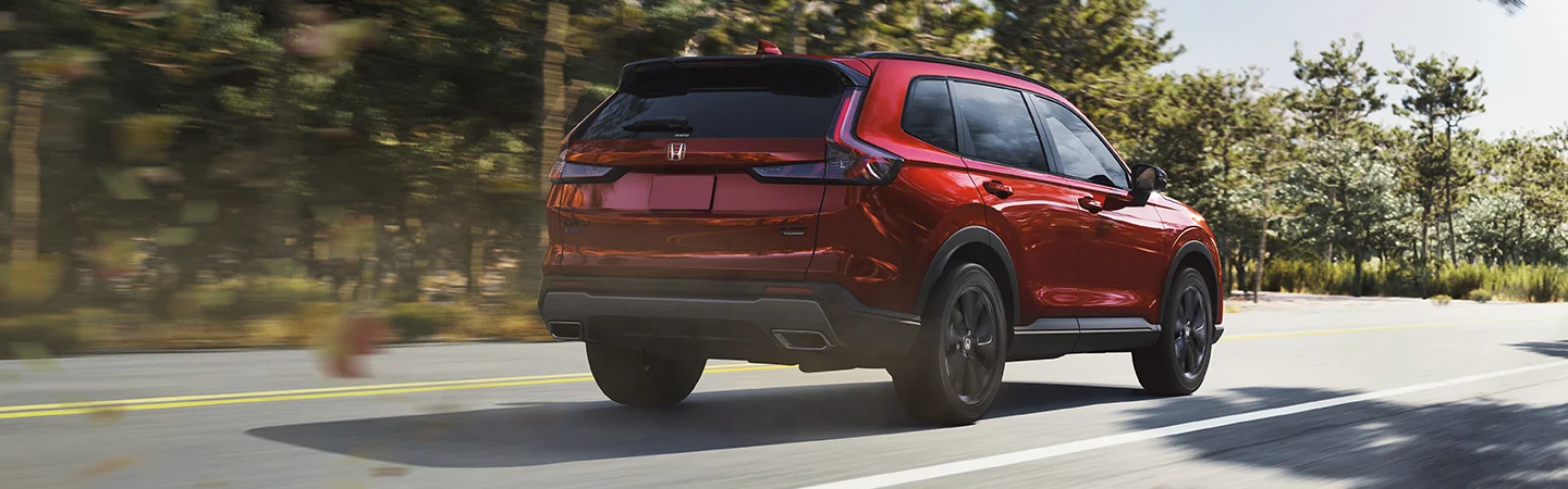 Rear view of the 2026 Honda CR-V Hybrid driving on a country road