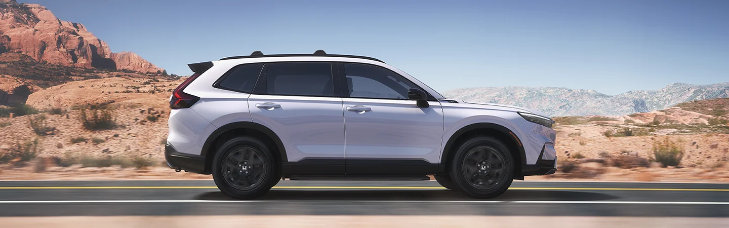 Side view of the 2026 Honda CR-V Hybrid driving on a desert highway