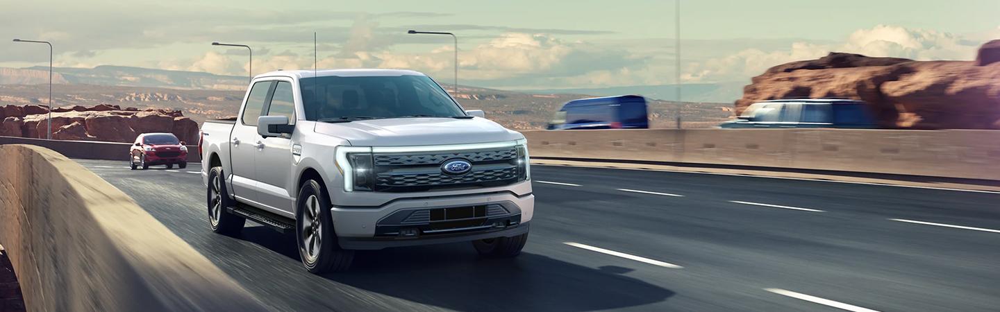 White 2022 Ford F-150 Lightning on highway