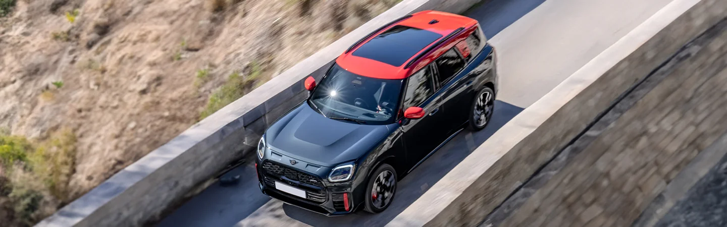 Top view of a black 2025 JCW Countryman ALL4 driving on a bridge