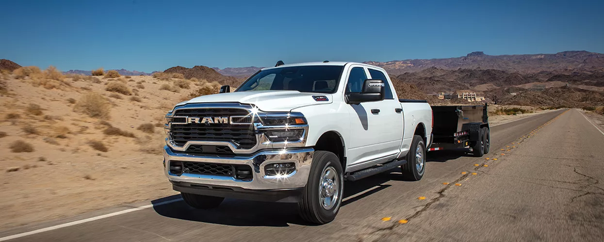 RAM Truck towing a trailer and driving down a road