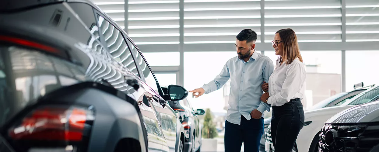 Couple looking at a vehicle in a kia dealership