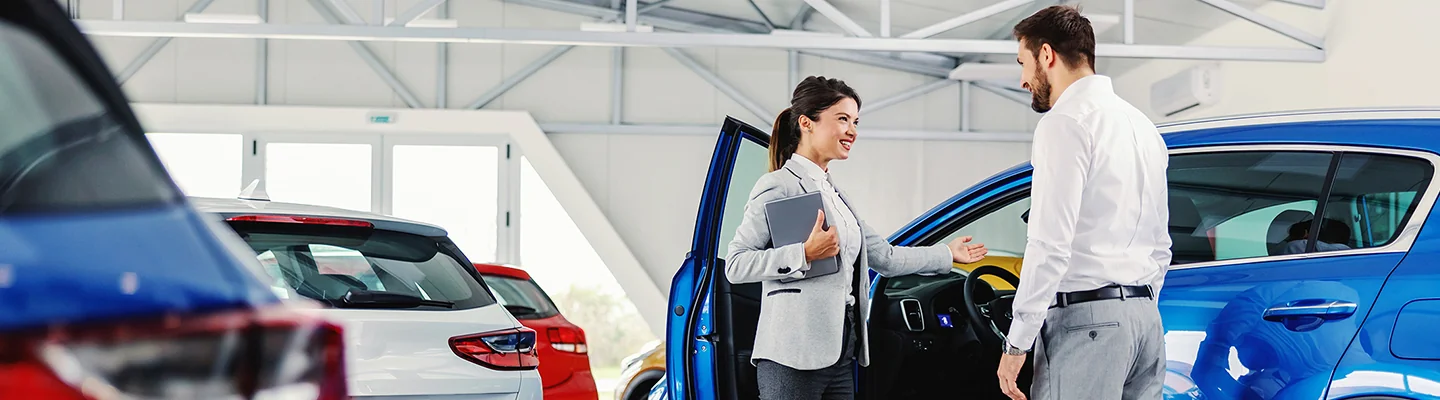 a customer getting into car after service with service representative detailing the services done