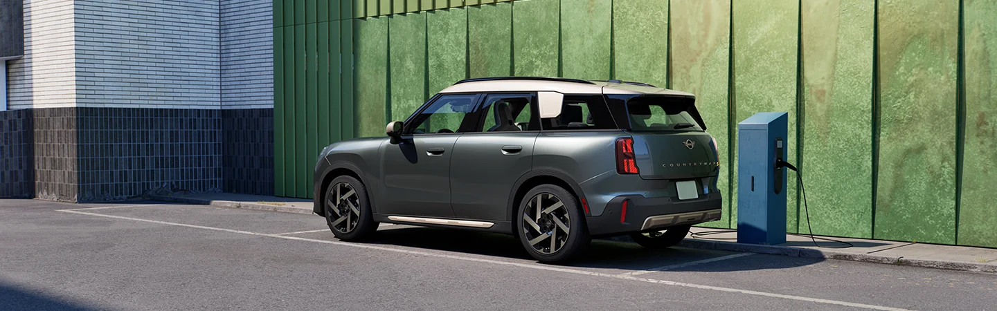 Side view of a parked gray 2025 MINI Countryman SE ALL4 at a charge station