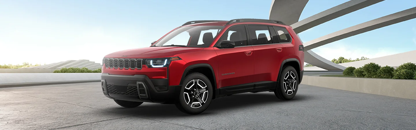 Front side view of a parked red 2026 Jeep Cherokee in a court yard
