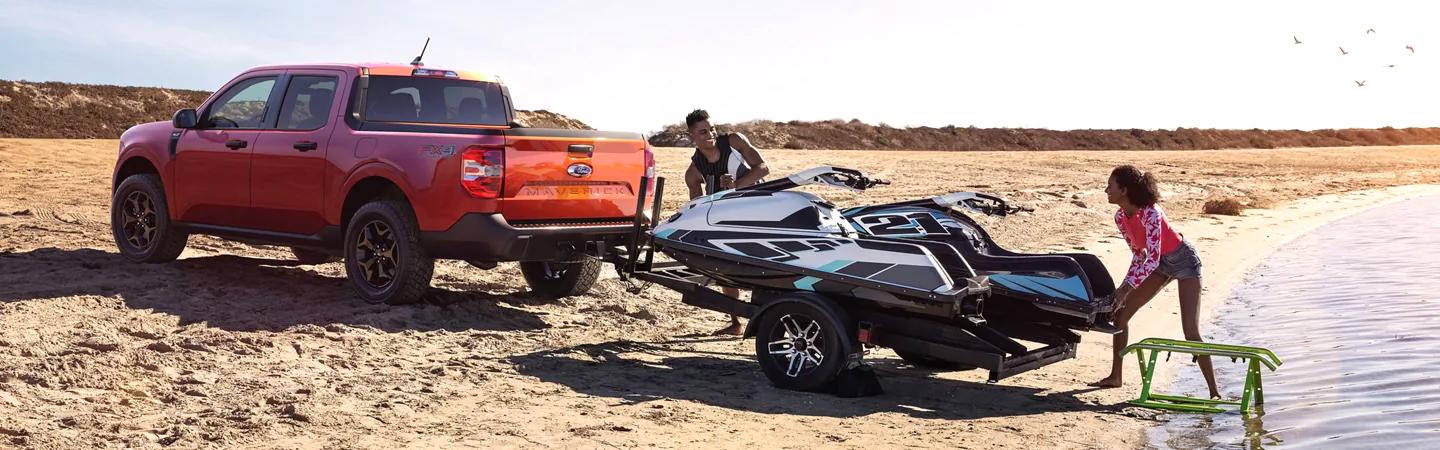 Red 2022 Ford Maverick at beach towing jet ski