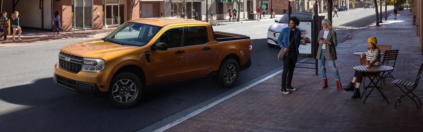 Yellow 2022 Ford Maverick parked on city street with pedestrians