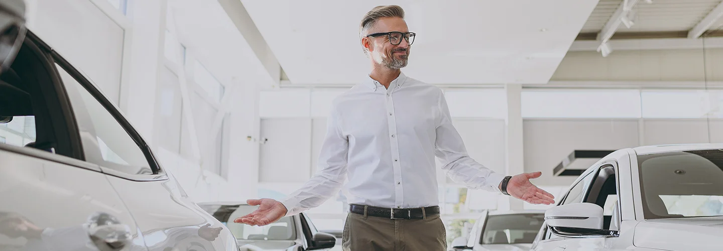 man in white shirt looking at cars