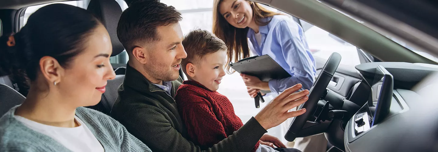 INFINITI Sales person showing a family the inside of a new INFINITI