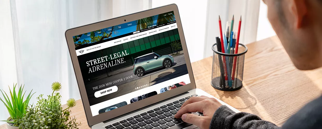 view of person on laptop browsing the a MINI of South Miami dealership website