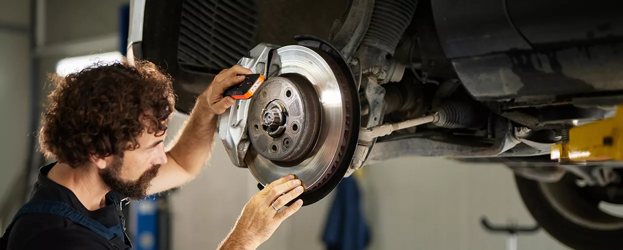 Service mechanic servicing a vehicle's brakes