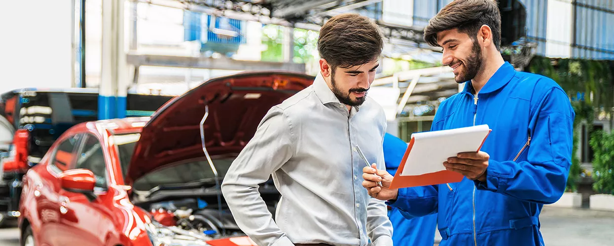 Service mechanic showing a customer a clipboard