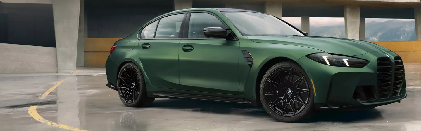 Side view of a parked green 2024 BMW M3
