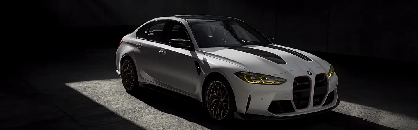 Front side view of a parked white 2024 BMW M3