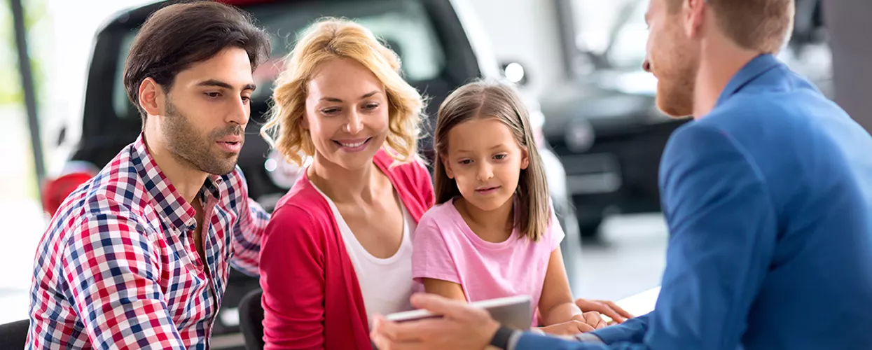 Family at a Toyota Dealership talking to a car salesman