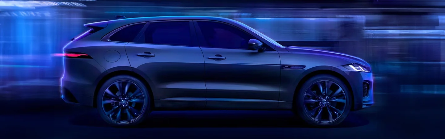 Side view of a 2025 Jaguar F-PACE driving in the city