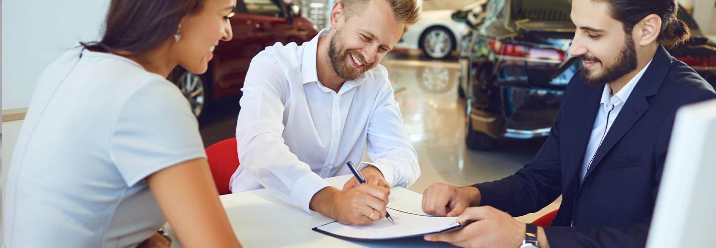 Customer signing papers with salesperson