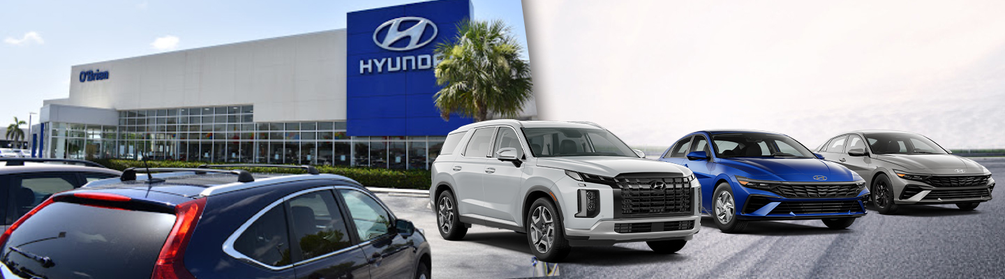 Front view of dealership next to lineup of Hyundai vehicles