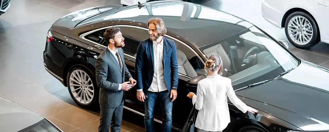 Car salesman shwoing two people a new BMW