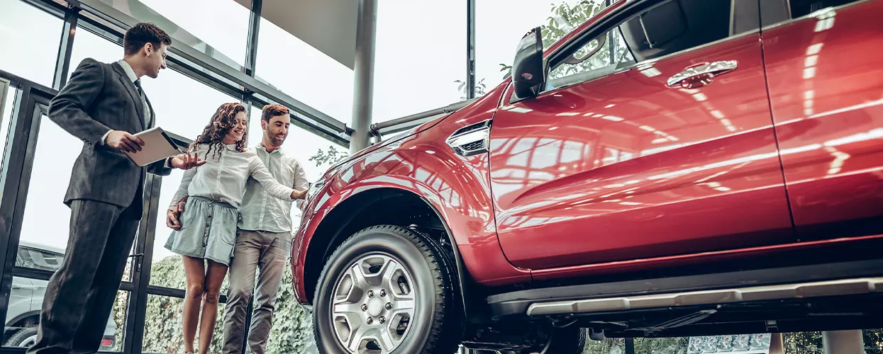 Couple looking at a new vehicle at a car dealership