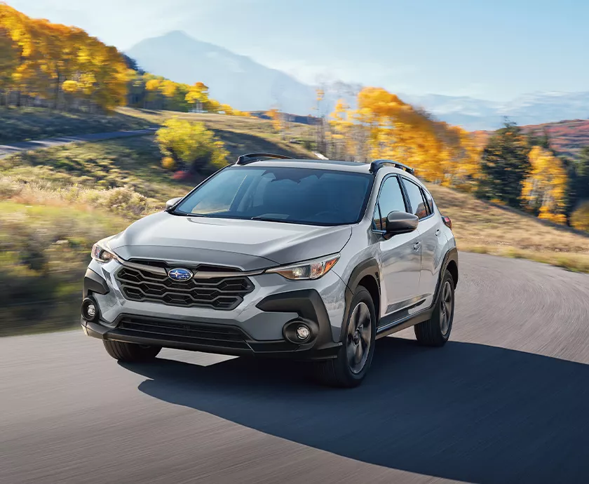 Front view of s gray Subaru Crosstrek driving on a road