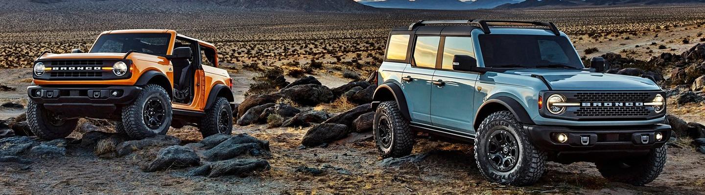 Blue and Orange 2021 Ford Bronco Sports Parked in Desert on Rocks