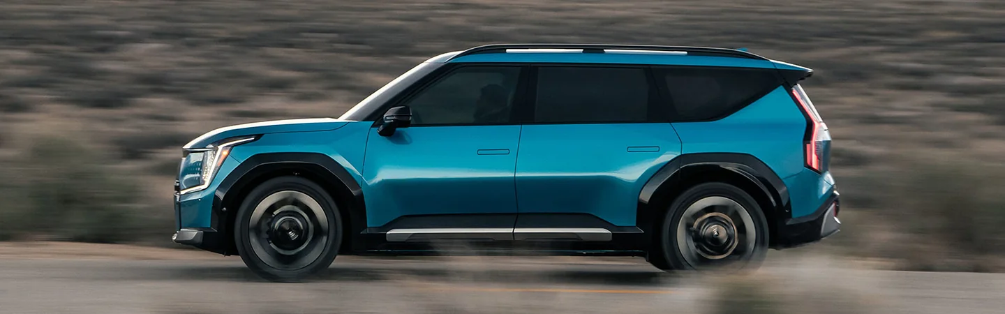 2024 Kia EV9 vs Rivian R1S blue side view