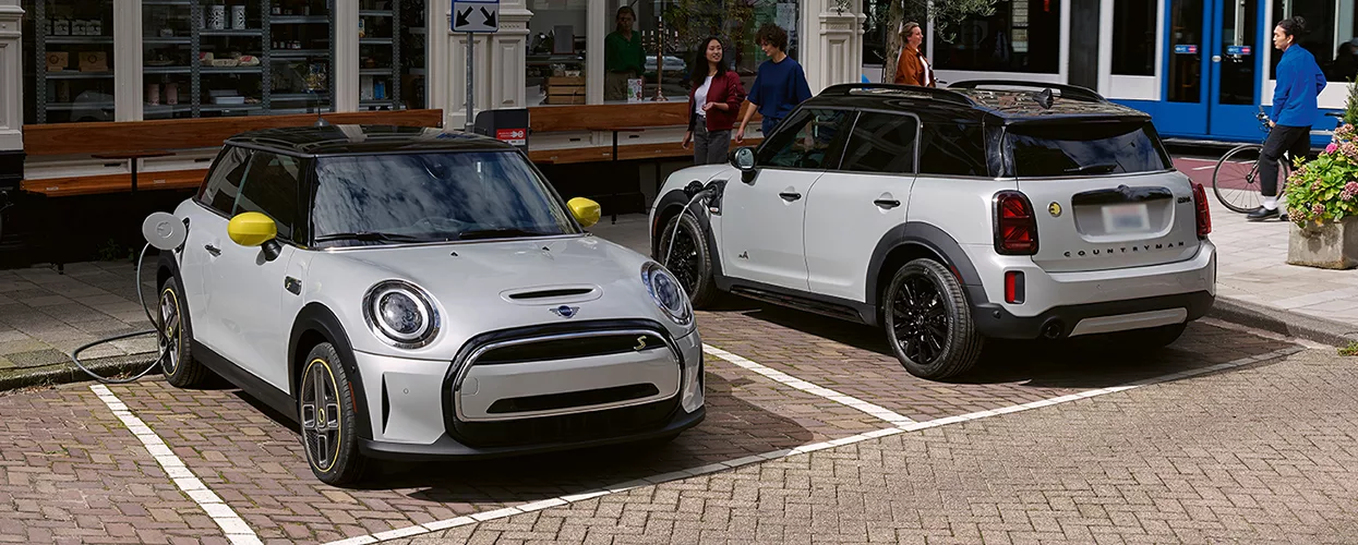 Two electric MINI vehicles parked side by side in charging ports