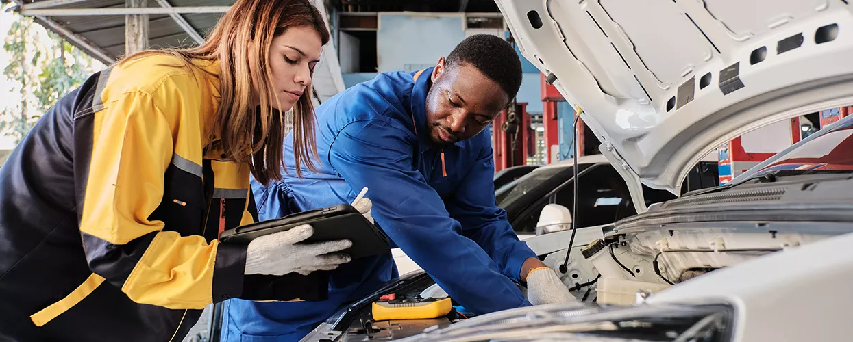 Ford technician performing routine maintenance in a service bay