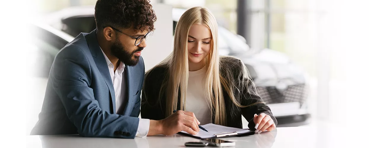 Car salesman walking a customer through a contract