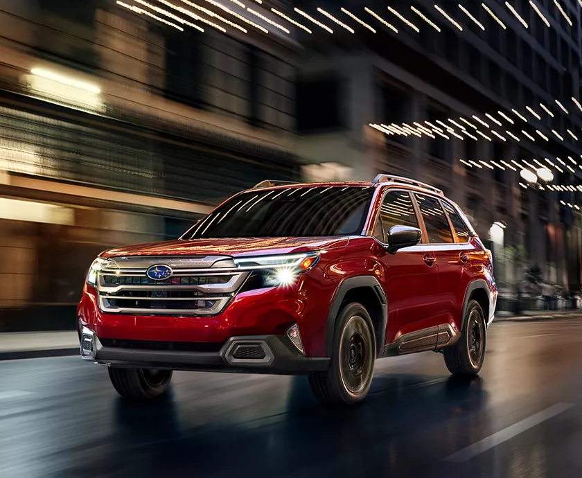Front view of a red Subaru Forester driving in the city