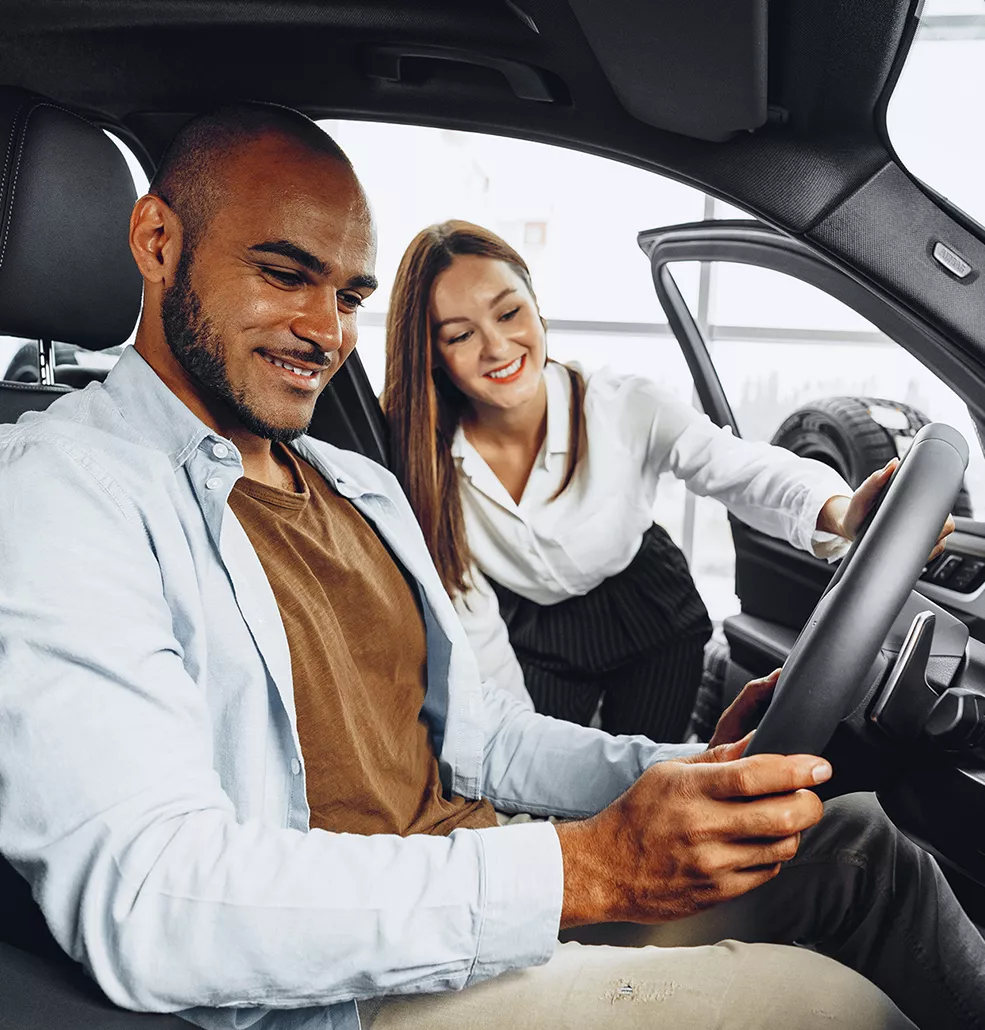 Couple looking at a new vehicle in a car dealership