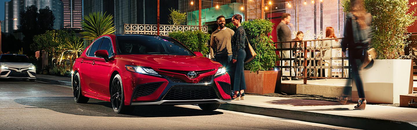 Red 2020 Toyota Camry Parked On City Street at Night