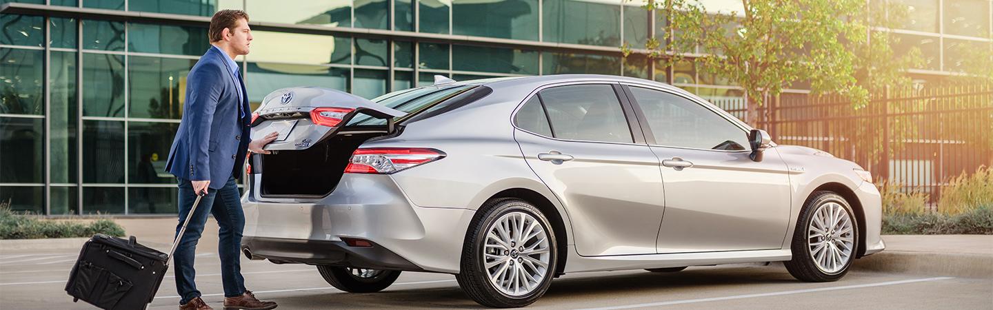 White 2020 Toyota Camry With Businessman Loading Open Trunk