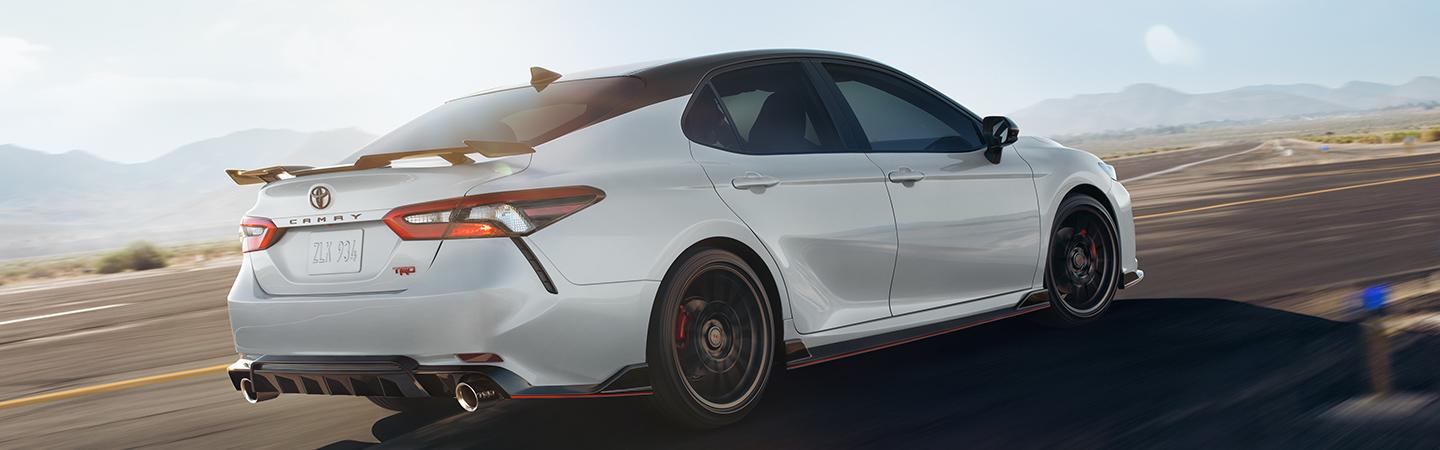 White 2020 Toyota Camry Driving Fast on Road by Mountains